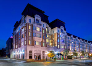 Photo of Hotel Commonwealth, a brick and concrete building with a mansard roof.